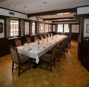uma longa sala de jantar com uma longa mesa e cadeiras em Landgasthaus Gieseke-Asshorn em Bohmte