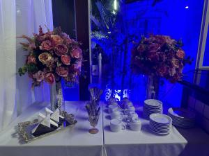 a table with flowers and cups and plates on it at Hotel Pousada Irmaos Freyhardt in Rio de Janeiro