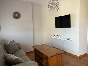 uma sala de estar com um sofá e uma mesa em Balcón de La Iruela em La Iruela