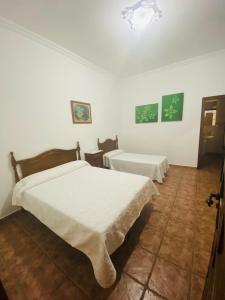 - 2 lits dans une chambre aux murs blancs dans l'établissement VFT Las Piedrecitas, à Hornachuelos