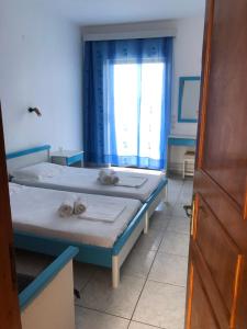 een slaapkamer met 2 bedden en een raam bij Diomare Villas in Kypseli