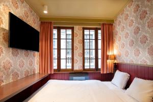 um quarto de hotel com uma cama e uma televisão de ecrã plano em Smartflats - the Place Brussels em Bruxelas