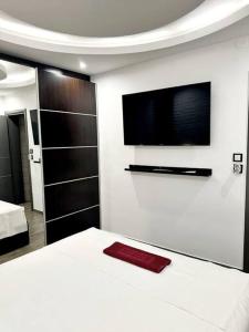 a bedroom with a bed and a flat screen tv at Sevi House Suite in Thessaloniki