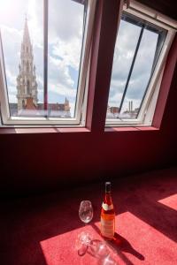 uma garrafa de vinho sentada numa mesa ao lado de uma janela em Smartflats - the Place Brussels em Bruxelas