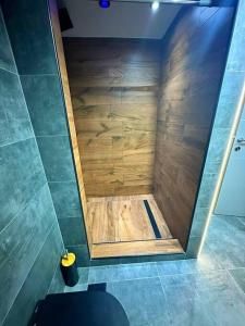 a shower in a bathroom with a wooden wall at Sevi House Suite in Thessaloniki