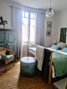 a bedroom with a bed and a table and a window at La Maison Gaston in Vernon