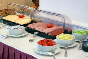 un buffet con tazones de comida en una mesa en City Hotel Pilvax, en Budapest