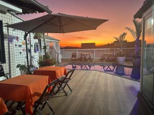 a patio with tables and an umbrella and a pool at Hotel Pousada Irmaos Freyhardt in Rio de Janeiro