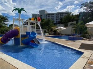 a pool with a water slide in a resort at Park Veredas in Rio Quente