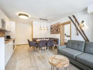 a living room with a couch and a dining room at Tauernlodge Sonnblick Top 3 in Mühlbach am Hochkönig