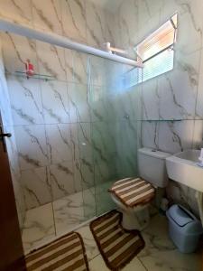 a bathroom with a shower and a toilet and a sink at Chalés Cantinho Da Mary in São Miguel dos Milagres