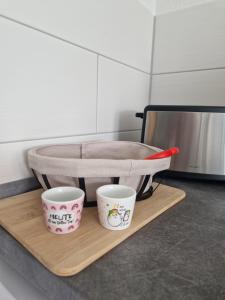 two cups sitting on a cutting board on a counter at Ferienwohnung Relax in Ilsenburg