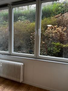 duas janelas num quarto com vista para um jardim em Zentral Hochparterre garten em Wuppertal