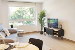 a living room with a couch and a tv at Piso con vistas al Jardín de San Esteban in Murcia