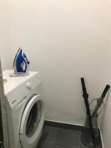 a white washing machine in a room with a vase at My Nest, 5 minutes to the Dragon Bridge in Ljubljana
