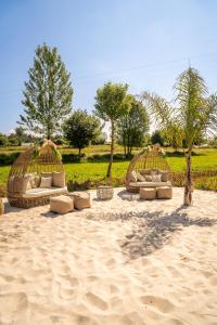 duas cabanas de palha com almofadas na areia em Bruval Eco Retreat em Sandim