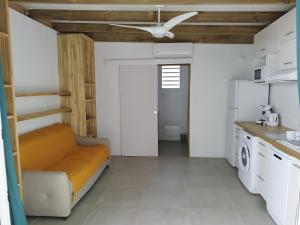 uma sala de estar com um sofá e uma ventoinha de tecto em Studio Ti Bambou em La Trinité