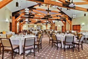 un salón de banquetes con mesas y sillas blancas en Pine Barn Inn, en Danville