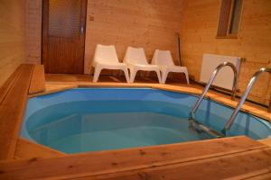 a jacuzzi tub in a room with four chairs at Wellness hotel Sauna in Malá Morávka