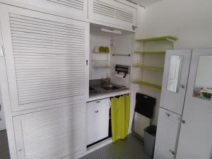 a kitchen with white cabinets and a sink at Studio 4 personnes au pied des piste plateau de Bonascre - Ax 3 domaines Eté Hiver in Ax-les-Thermes