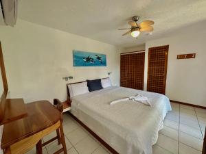 a bedroom with a bed and a ceiling fan at Hotel Silberstein in Puerto Ayora