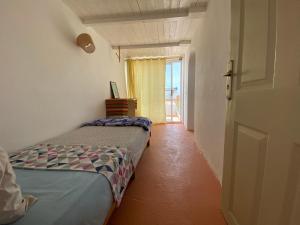 a room with two beds and a door with a window at Surf HouseMaroc in Essaouira