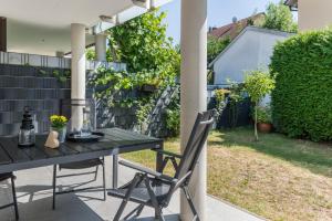 einen Tisch und Stühle auf einer Terrasse mit Garten in der Unterkunft Fewo Köse in Uhldingen-Mühlhofen