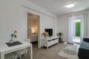a white living room with a couch and a table at Fewo Köse in Uhldingen-Mühlhofen