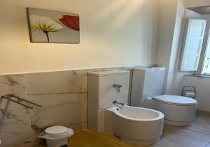 a bathroom with a toilet and a painting on the wall at B&B Giardino delle Camelie in Capannori