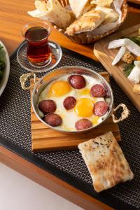 una mesa con una sartén de huevos y un poco de pan en Tasvir Hotel, en Bukhara
