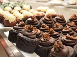 a bunch of chocolate cupcakes sitting on a tray at Devine Unit by Planet Hollywood Casino Strip Las Vegas in Las Vegas