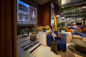 a lobby with couches and a fireplace in a building at Moxy Sydney Airport in Sydney