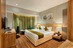 a hotel room with a bed and a television at Travancore Court in Cochin