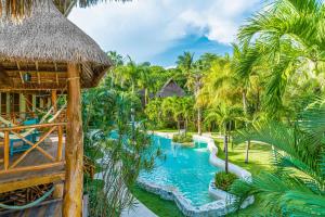 a resort with a swimming pool and palm trees at Mahekal Beach Front Resort & Spa in Playa del Carmen