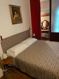 1 dormitorio con 1 cama y una foto en la pared en B&B SCACCIA PENSIERI, en Tarcento