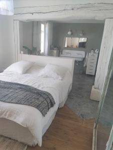 a bedroom with a large white bed in a room at La Maison Gaston in Vernon