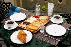 una mesa con una bandeja de pan y tazas de café en Tasvir Hotel, en Bukhara