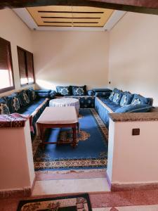 a living room with a blue couch and a table at La Novia Marrakech in Tahannout