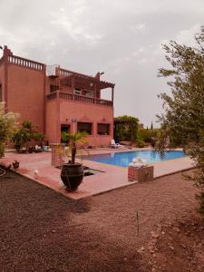 a house with a pool in front of a building at La Novia Marrakech in Tahannout
