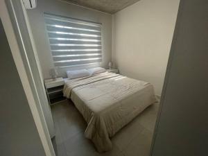 1 dormitorio con 1 cama grande y ventana en Dpto zona Luque, cerca del aeropuerto y centros comerciales, en Luque