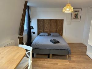 sypialnia z łóżkiem, stołem i lampą w obiekcie Sceaux - Locations de Charme dans Maison w mieście Sceaux