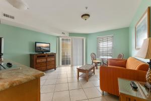 a living room with a couch and a tv at Nw Condo Across Beach Pool & Parking in North Wildwood