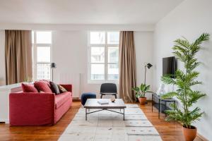 uma sala de estar com um sofá vermelho e uma mesa em Smartflats - Central Antwerp em Antuérpia