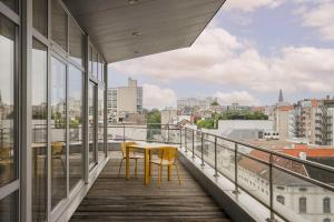 einen Balkon mit einem Tisch und Stühlen auf einem Gebäude in der Unterkunft Smartflats - Central Antwerp in Antwerpen