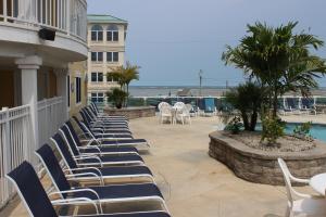 a row of lounge chairs on a balcony with the ocean at Nw Vacation Rental Condo W Pool & Ocean Views in North Wildwood