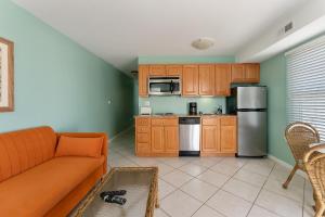 a living room with a couch and a kitchen at Partial Ocean View Condo W Pool & Parking in North Wildwood