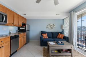 a living room with a blue couch and a kitchen at Nw Condo W Private Balcony & Pool in North Wildwood