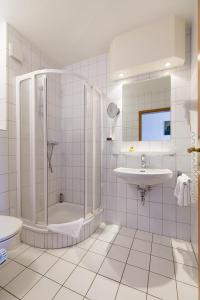 a white bathroom with a shower and a sink at Landgasthaus Gieseke-Asshorn in Bohmte