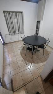 ein Zimmer mit einem Tisch und Stühlen auf einem Fliesenboden in der Unterkunft Eduardo in Malargüe
