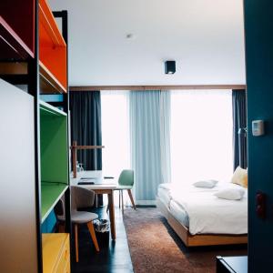 una camera con letto e scrivania e una camera da letto di Claudius Hotel a Bochum